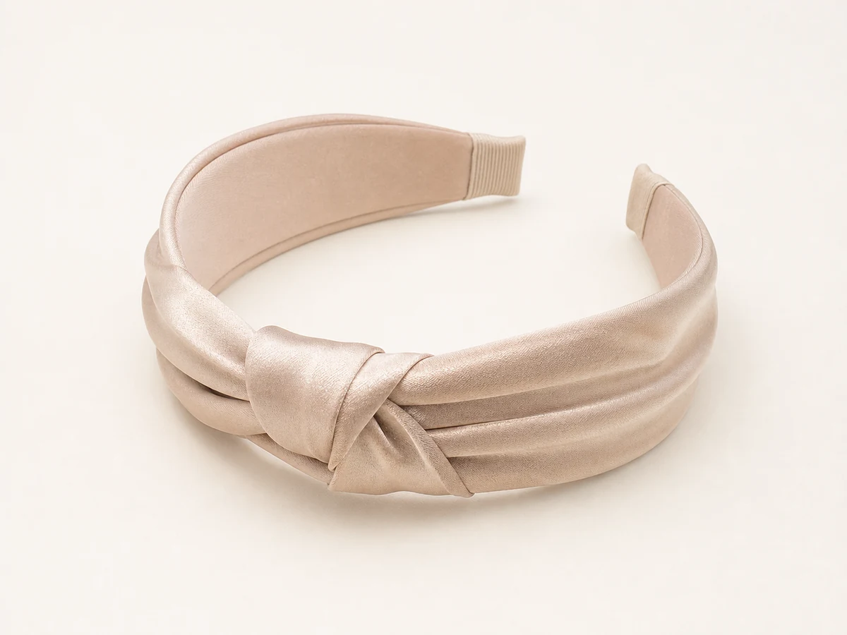 Champagne silk-look satin headband with a restrained low folded knot and clean side pleats