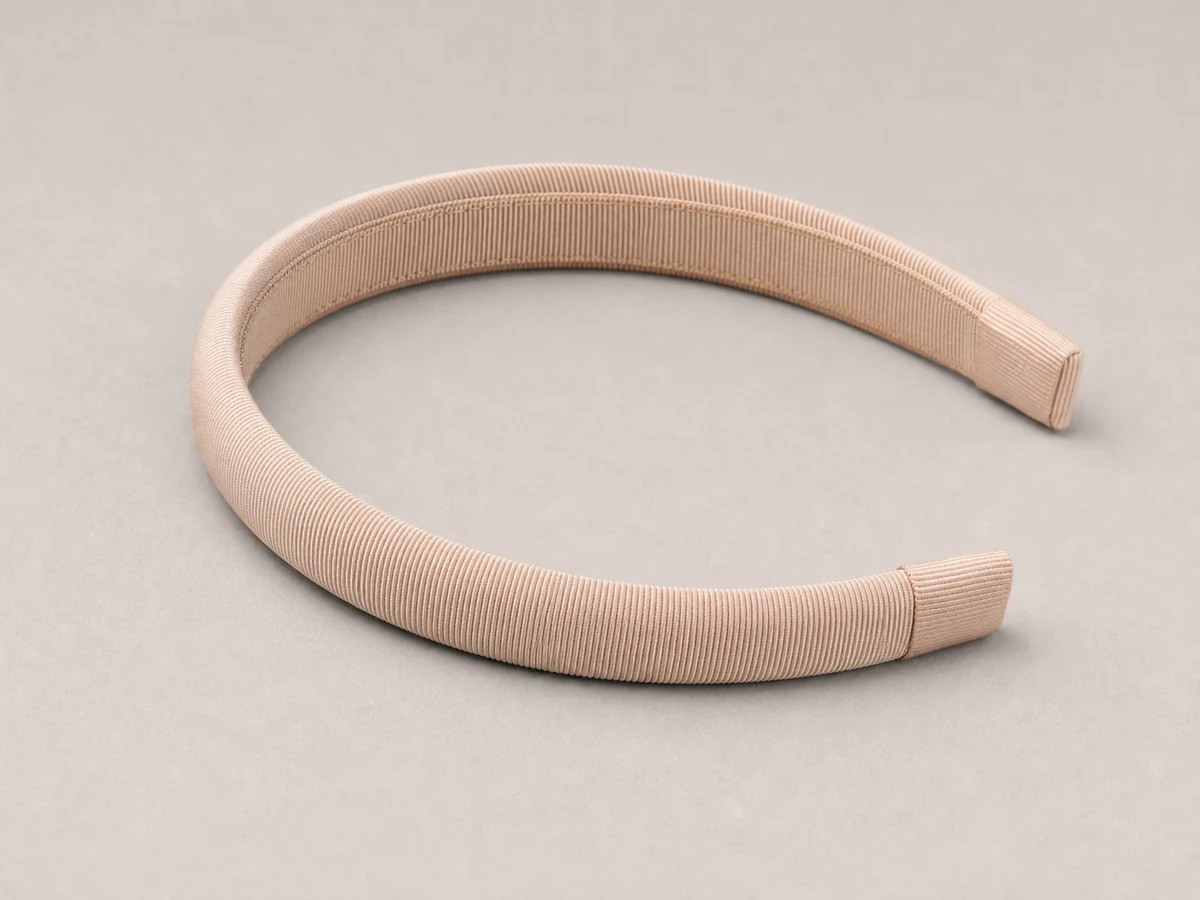 Slim champagne headband wrapped in fine ribbed faille with clean capped tips