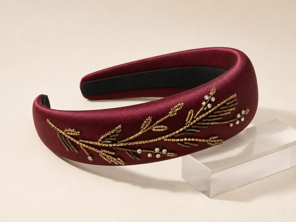 Oxblood satin wide padded headband with an asymmetric hand-beaded abstract botanical branch