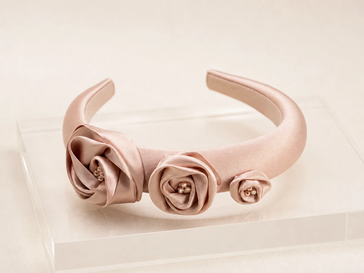 Champagne rose satin headband with three low-profile folded satin rosettes and tonal bead centers