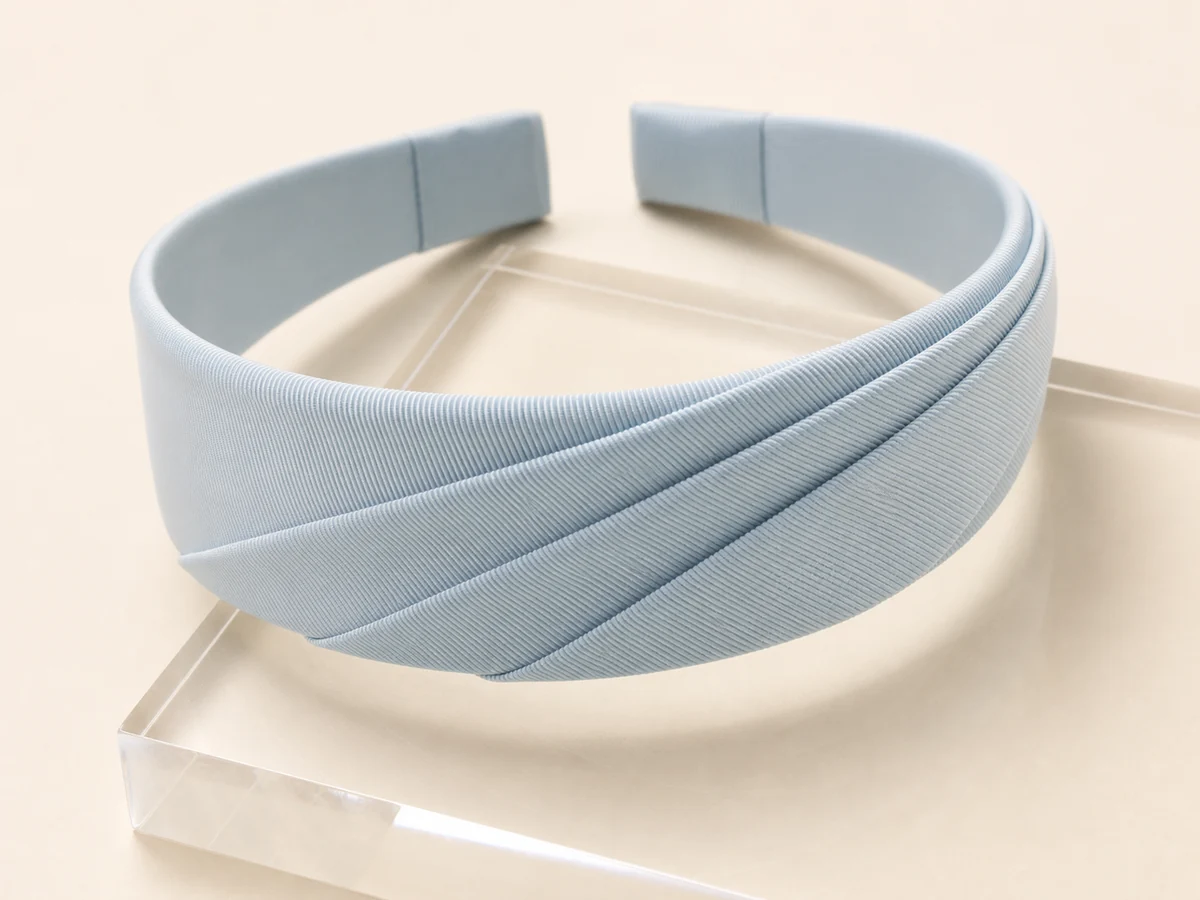 Powder blue faille headband with precise diagonal knife pleats across one side