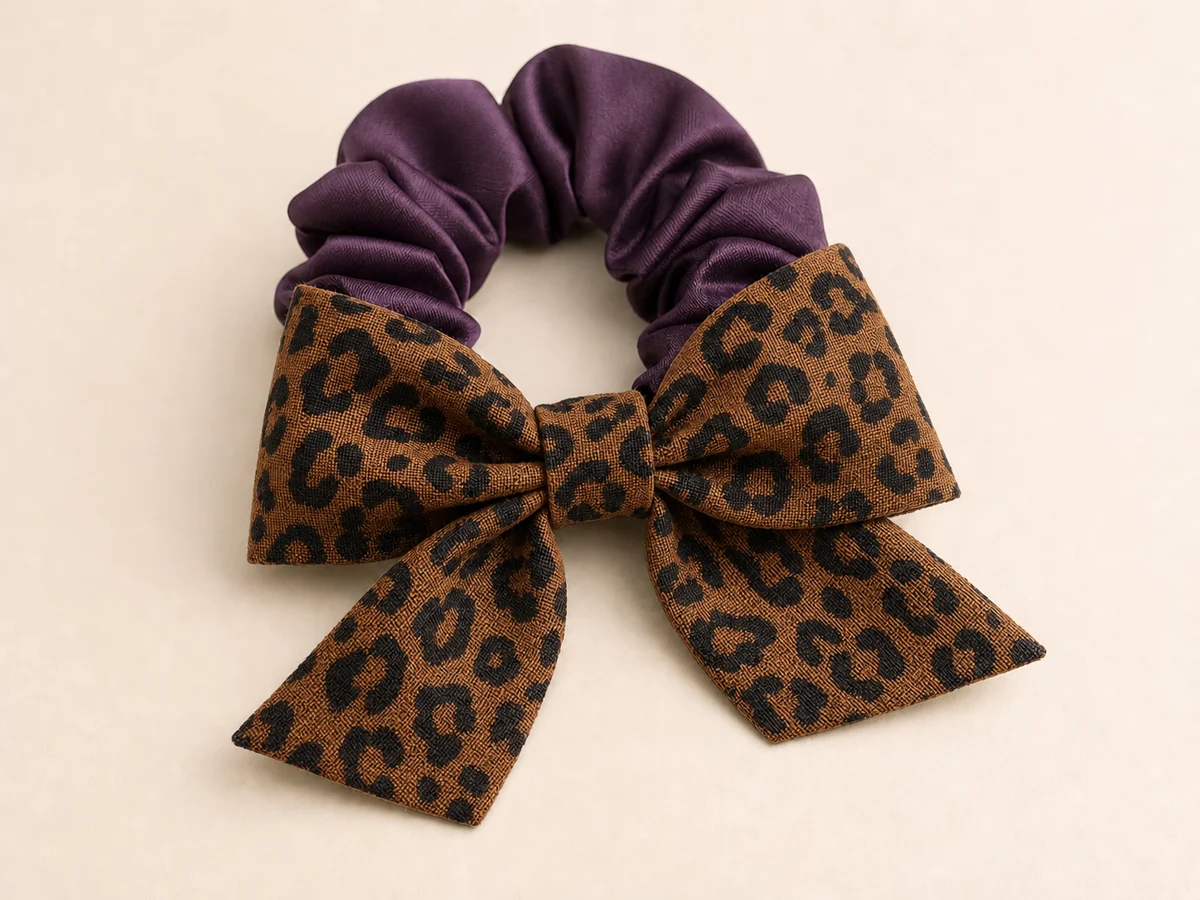 Deep plum satin scrunchie with a warm brown and black leopard-print bow